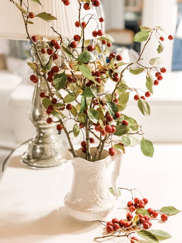 pitcher with branches and berries that I found in my yard for a way to celebrate christmas on a budget