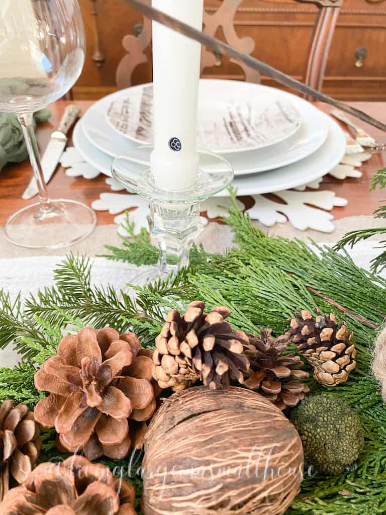 picture of a place setting along with a part of the greenery and pinecones on the woodland christmas tablescape