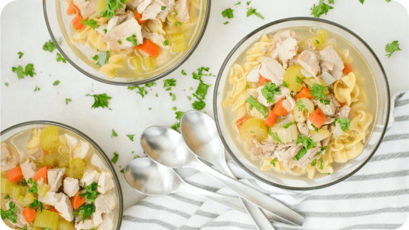 three bowls of classic chicken noodle soup