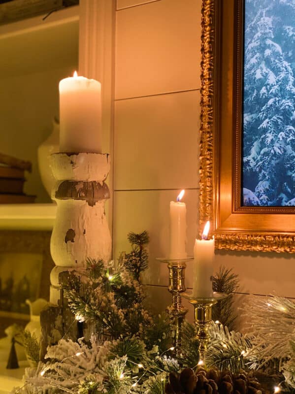 the corner of the mantel with candles lit and greenery - Living Large in A Small House - Christmas House Tour
