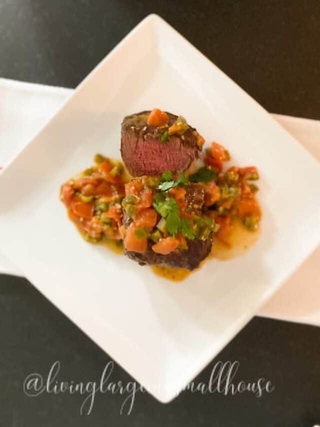 a medium-rare steak with southwestern sauce over it.
