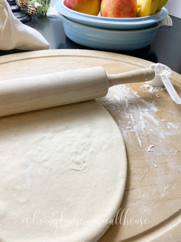 sourdough starter discard pizza crust rolled out on a board