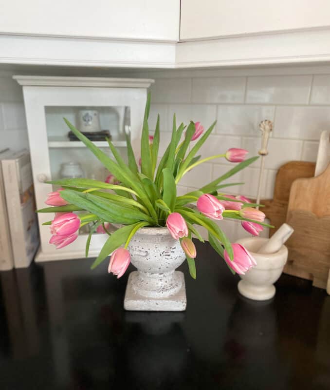 a cement urn with pink tulips on the kitchen counter for Valentine's Day decor