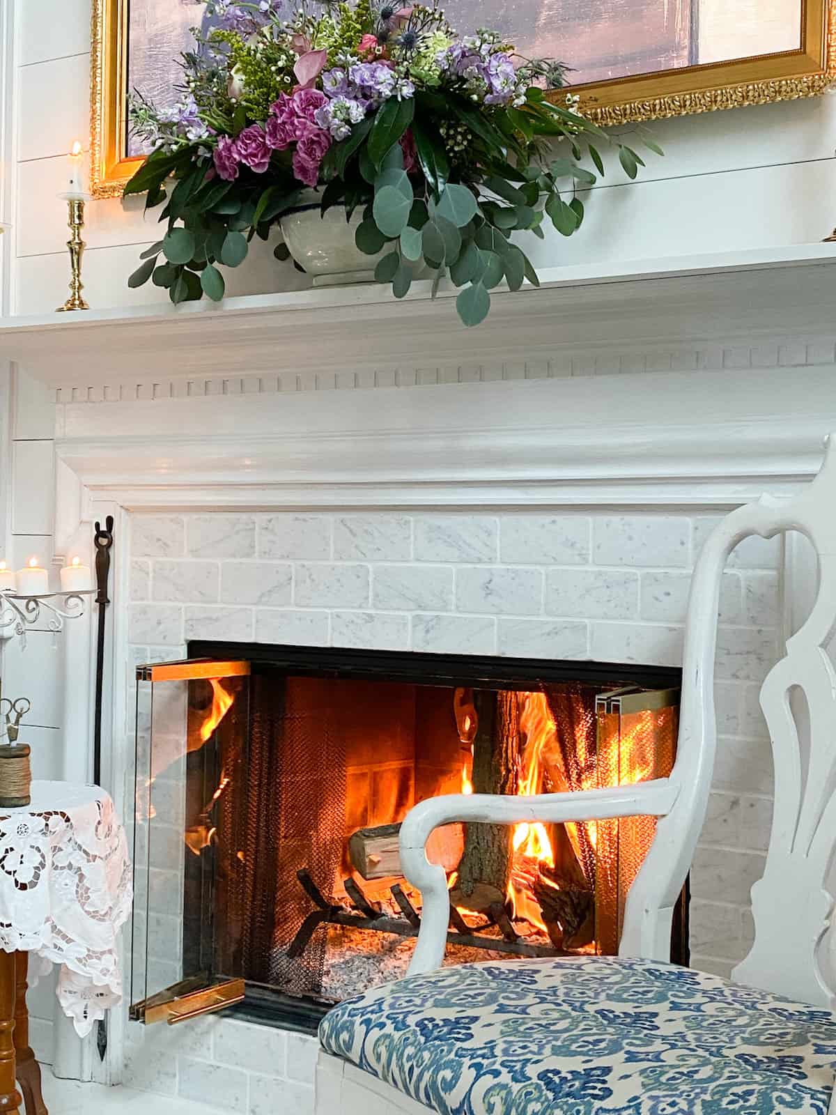side view of a fire in the fireplace and chairs flanking the fireplace just like a manor parlor