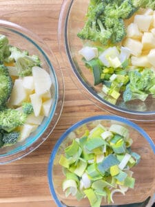 three glass bowl. One with the leeks, on with 2/3 of the potatoes and broccoli and another with the 1/3 broccoli and potatoes