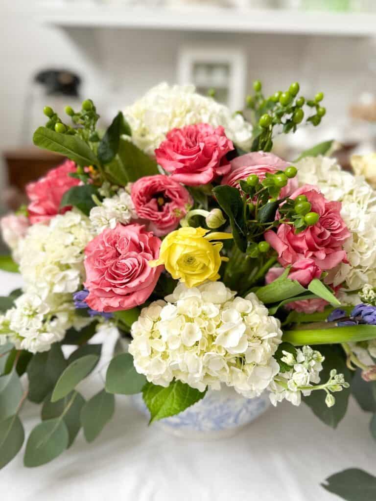 close-up of a spring floral arrangement with cottage roses, ranunculus, tulips, hydrangeas and more