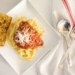 spaghetti with traditional italian pasta sauce plated with garlic bread