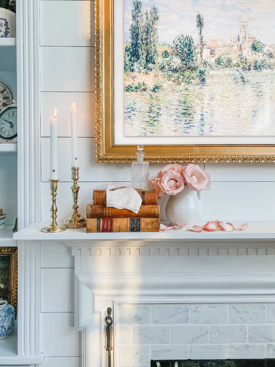 my white fireplace mantel with vintage decor of old books, ironstone and old brass candle sticks