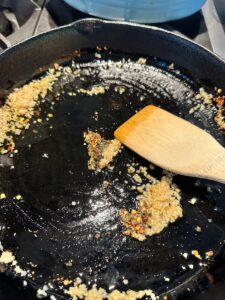 a cast iron pan with olive oil, garlic and herbs
