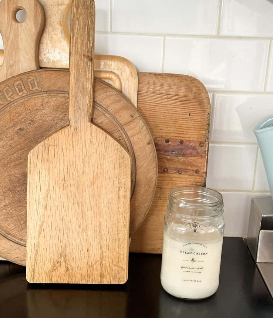 the vintage cutting boards in my kitchen with a fall candle next to it