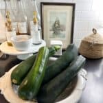 a bowl full of fresh zucchini from my garden and I'm going to make zucchini boats stuffed with easy bolognese sauce