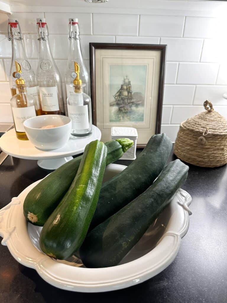 a bowl full of fresh zucchini from my garden and I'm going to make zucchini boats stuffed with easy bolognese sauce