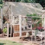 Side photo of our customized kit greenhouse and you can see the brick paver walkway and landscape block base created for the frame.
