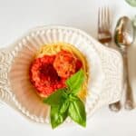 pasta, marinara and italian meatballs in a white bowl ready to eat.