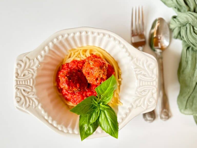 pasta, marinara and italian meatballs in a white bowl ready to eat.