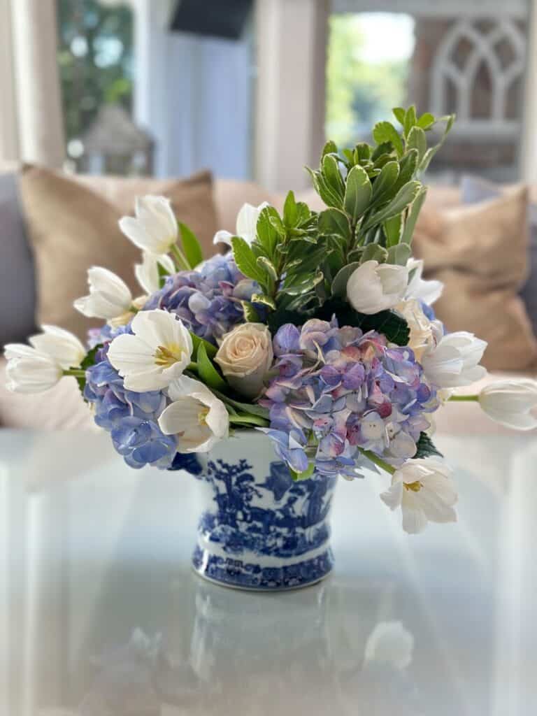 blue and white flowers arranged in a blue and white vase - organized home