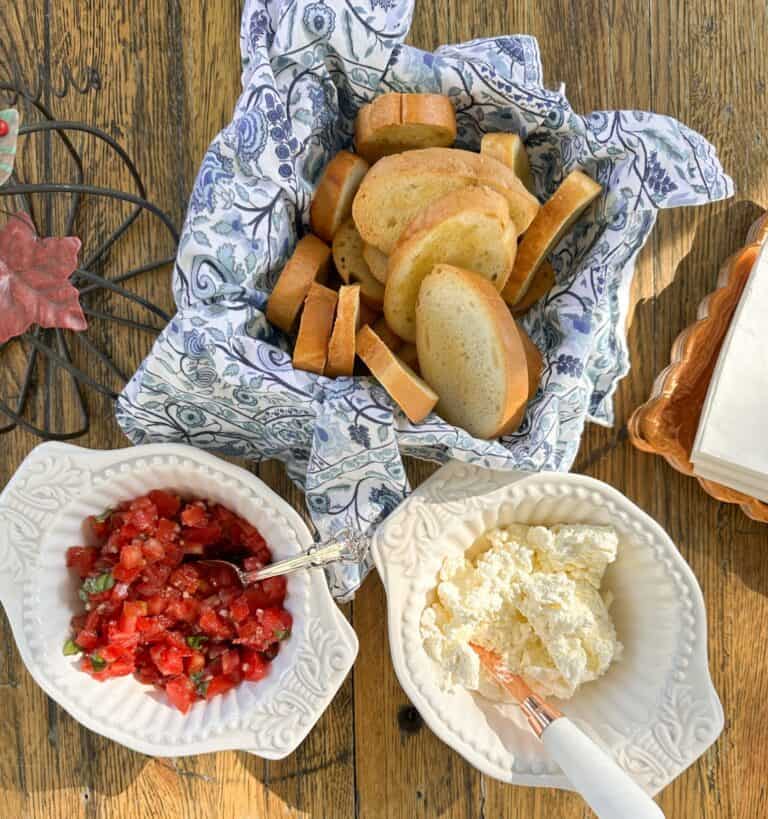 crostinis in basket, tomato salsa in a bowl and homemade ricotta in a bowl