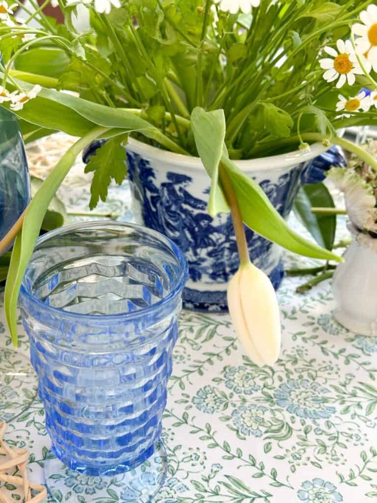 photo of a draping white tulip and the blue vintage water glass on the easter table