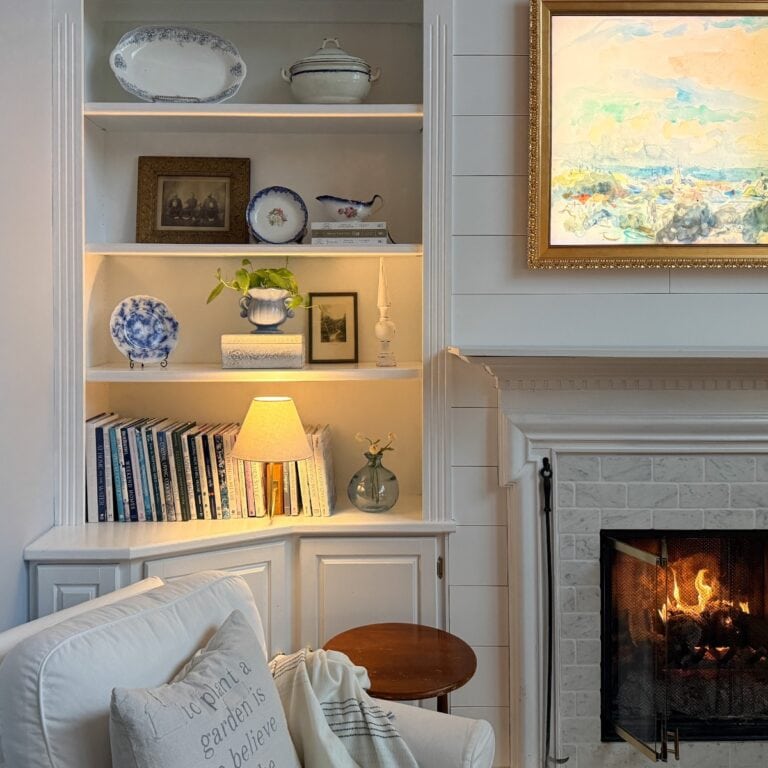 Cozy winter reading nook with an upholstered chair, soft lighting, neutral decor, and built-in shelves styled for a calm winter home.