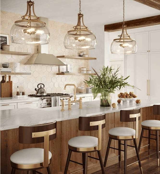 A modern kitchen designed for downsizing to a smaller home features a marble island with four wood and white chairs, gold accents, pendant lights, hexagon tile backsplash, open shelves, greenery in a vase, and fruit bowls on the counter.