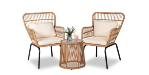 Two wicker armchairs with cream cushions are placed on either side of a round wicker side table with a glass top. Perfect for relaxing after a shopping trip, the table holds a small plant, a pink drink, and a yellow drink against a white background.