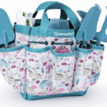 A small, colorful garden tote with a dinosaur print holds the latest teal plastic gardening tools—including a trowel, fork, and rake—in multiple outer pockets. The tote has a handle on top and the brand name "Grenebo" on the front.