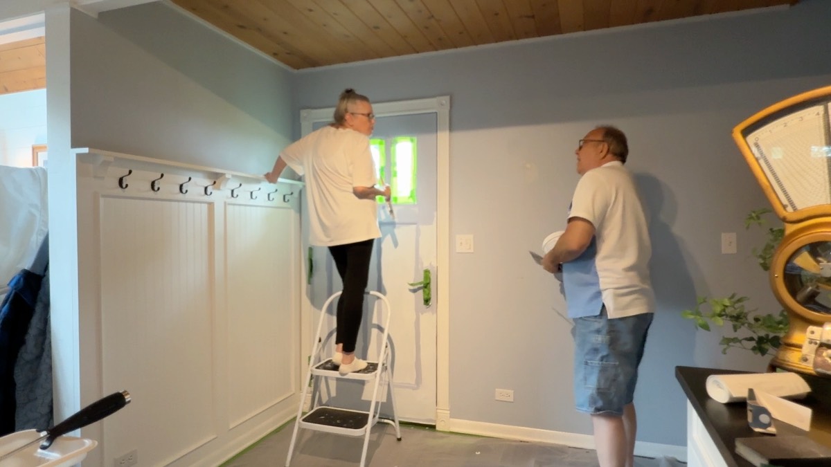 Two people painting a room, showing how to decorate a small home beautifully together with teamwork and creativity.