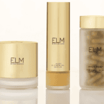 Three gold-capped ELM Biosciences skincare products, perfect for your next shopping haul: cream, serum, and supplements.