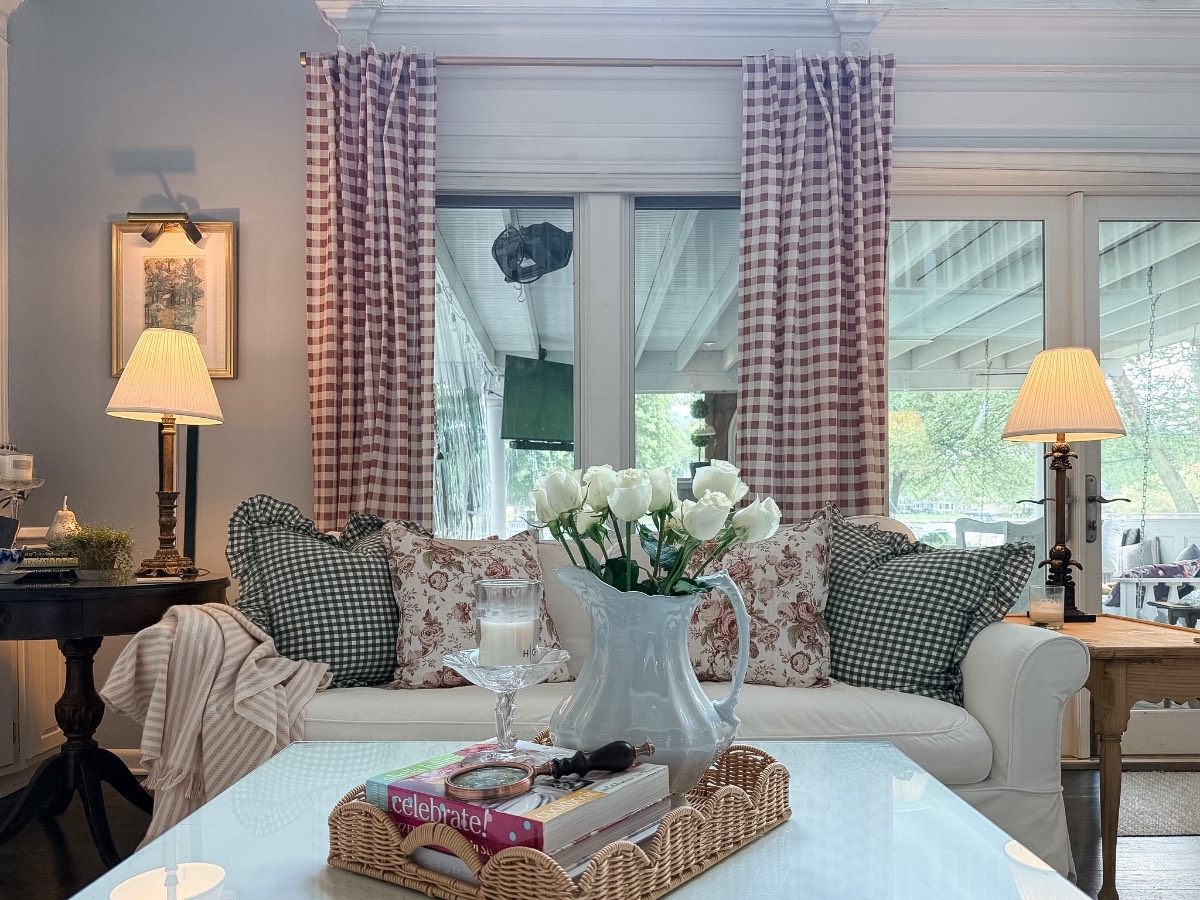 Cozy living room inspiration for how to decorate a small home beautifully with floral pillows and pink check curtains.