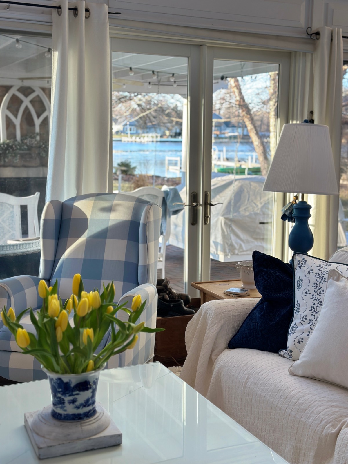 Sunny living room with blue accents and lake views—showing how to decorate a small home beautifully with color and light.