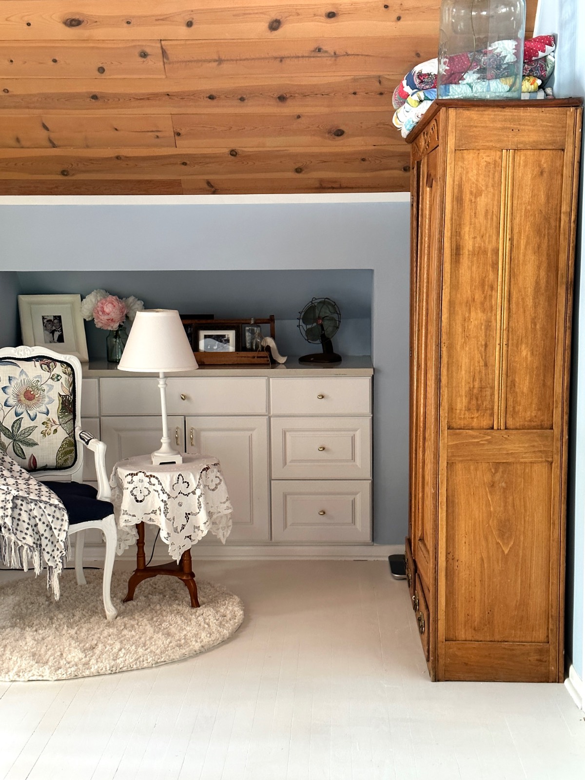 Cozy room shows how to decorate a small home beautifully with light blue walls, wood-paneled ceiling, and classic furnishings.