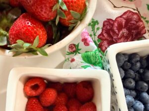 Bowls of fresh berries on a floral cloth—an easy idea for how to refresh your home for summer.