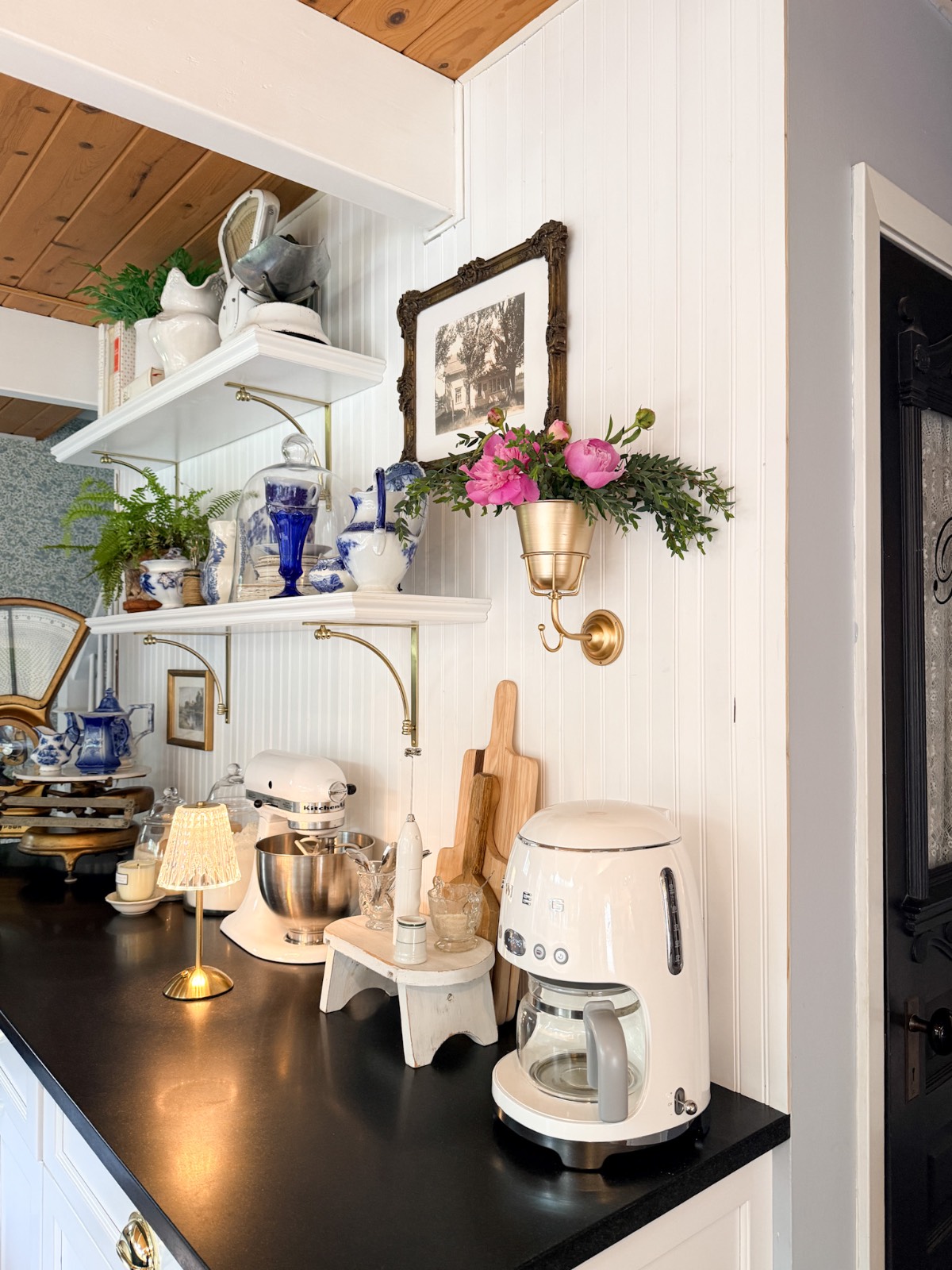 A cozy kitchen with black countertops, vintage appliances, and tips on how to decorate a small home beautifully.