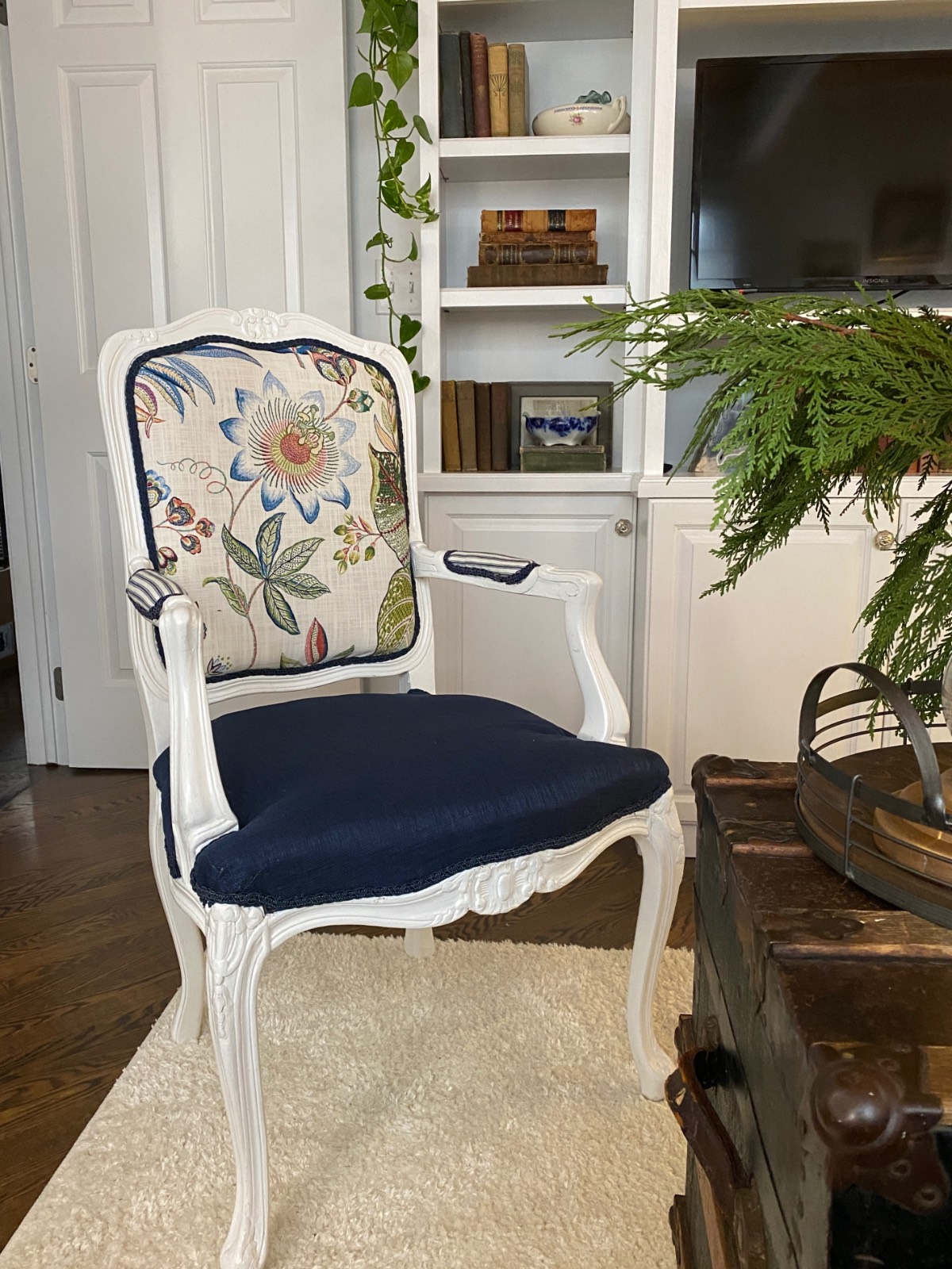 White armchair with a floral backrest and navy seat—perfect inspiration for how to decorate a small home beautifully.