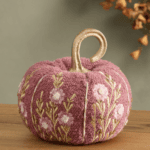 A pink textured pumpkin with embroidered flowers and a gold stem awaits your next Shopping with Friends adventure.