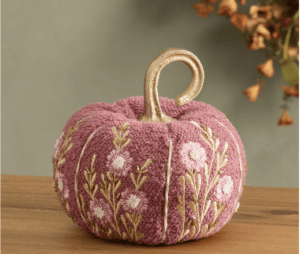 A pink textured pumpkin with embroidered flowers and a gold stem awaits your next Shopping with Friends adventure.