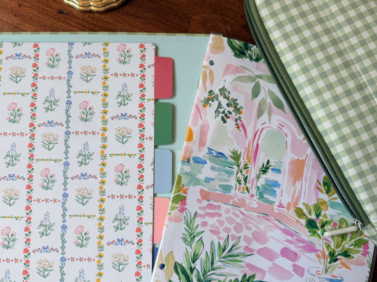 Colorful floral folders and a green gingham zip pouch overlap on a wooden table, perfect for stylish shopping organization.