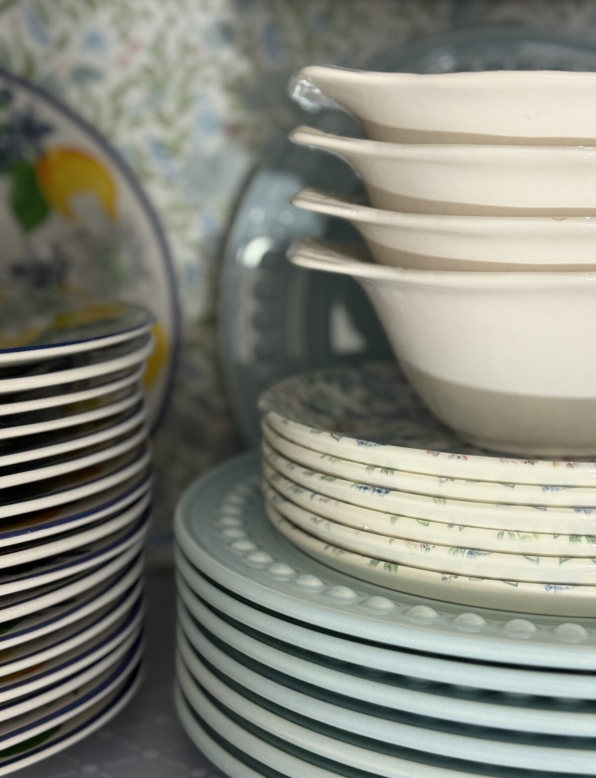 Stacks of assorted plates and bowls in pastel colors, perfect for organizing in your hosting closet or displaying on a shelf.