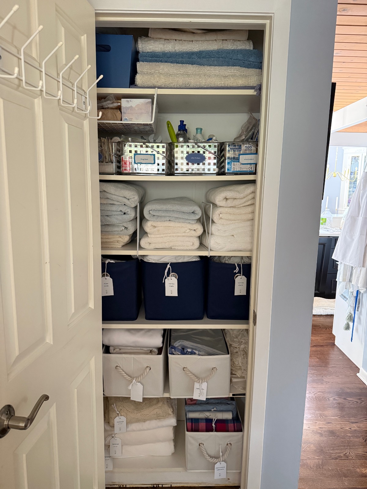 Closet transformation: shelves hold towels, bins, and baskets—everything neatly labeled in this hall linen closet.