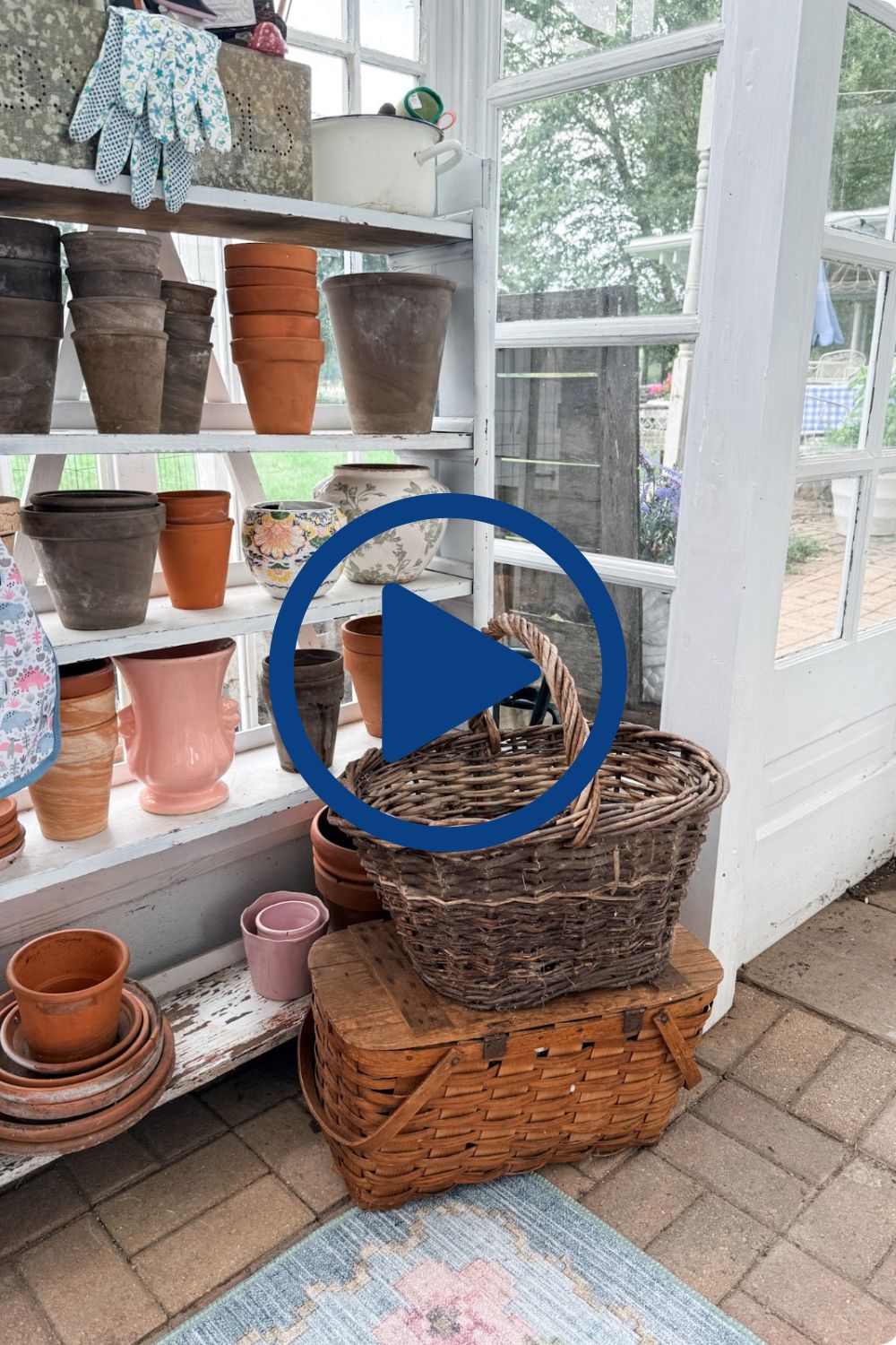 Shelves with flower pots, baskets, and garden gloves—perfect greenhouse styling for a sunny room with garden views.