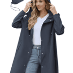 Woman in a dark blue raincoat with hood, perfect for shopping, jeans and white top, matching pouch also shown.