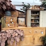 Curated vintage booth with furniture and vintage wares at a Michigan vintage market