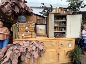 Curated vintage booth with furniture and vintage wares at a Michigan vintage market