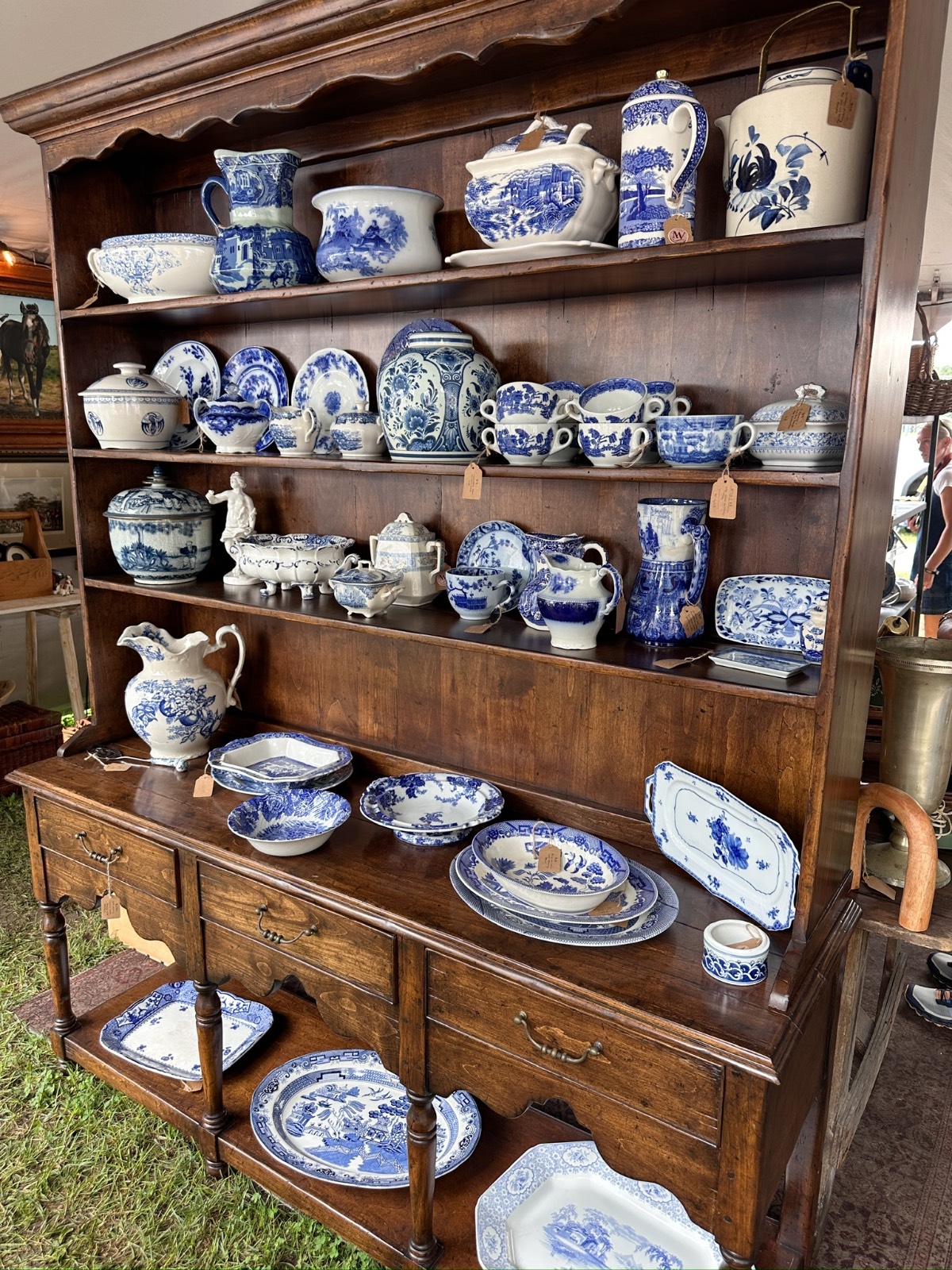 Dark wood hutch found at a cottage mercantile market, displaying blue and white porcelain with floral designs.