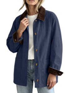 Woman shopping in a blue jacket with brown collar and cuffs, white shirt, and classic blue jeans.