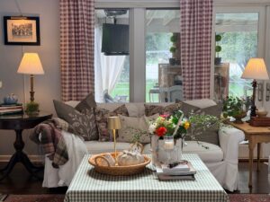 Cozy living room with a white sofa, plaid curtains, and muted fall decor for a charming vintage fall home tour feel.