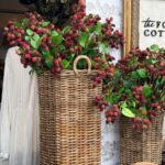 Two wicker baskets display the latest faux berry branches outside a shop with a “the Found Cottage” sign.