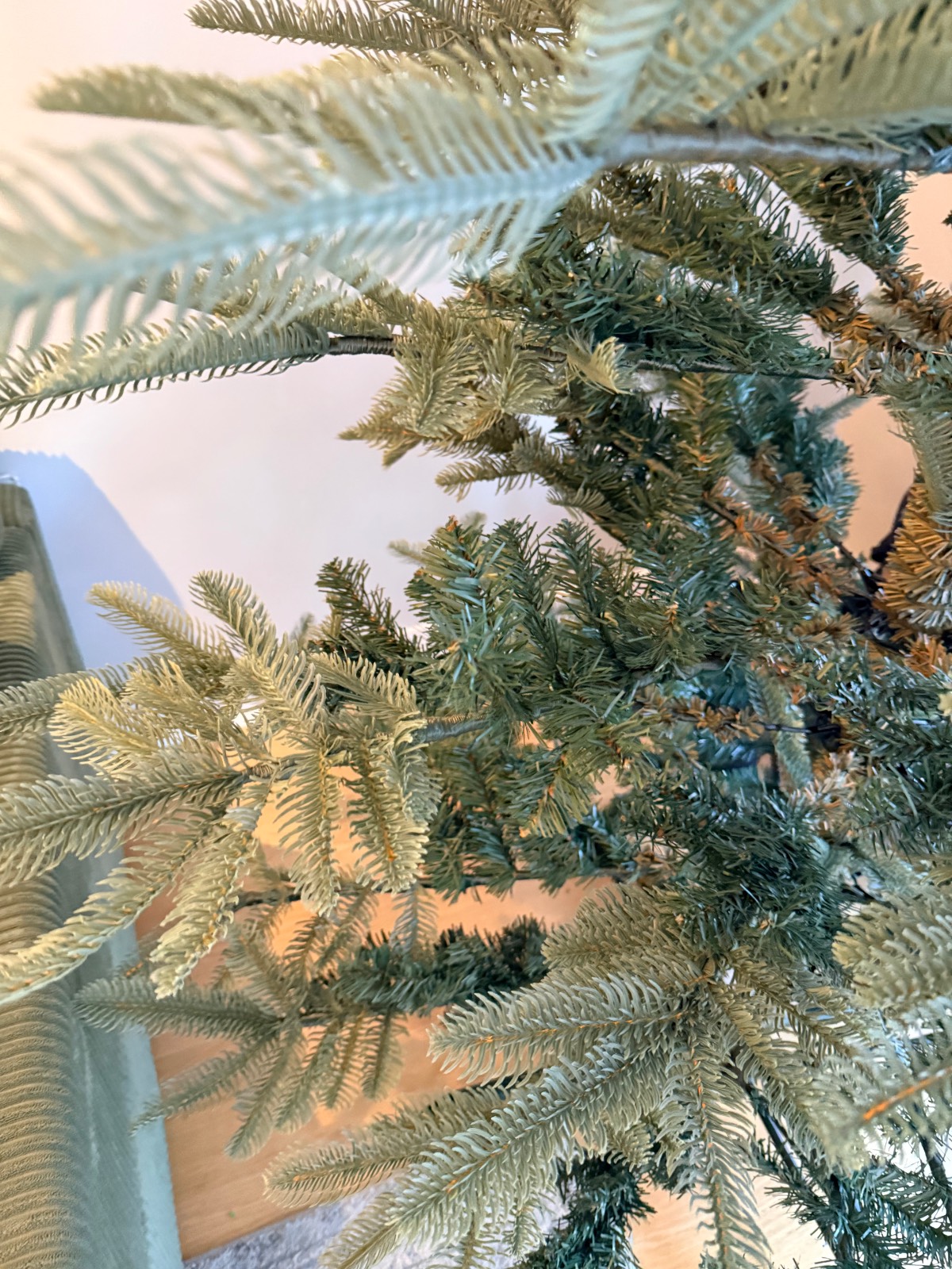 Close-up of artificial Christmas tree branches adorned with firecracker lights.