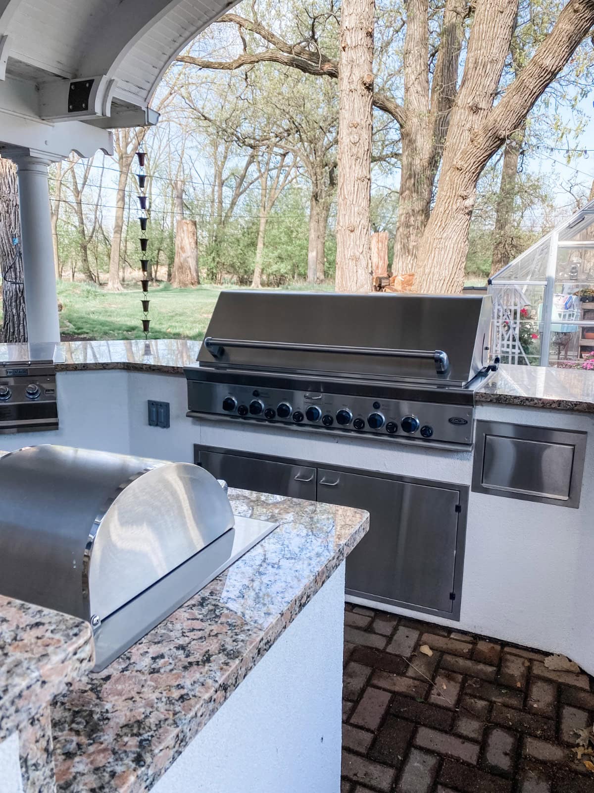 Stainless steel grills built into a granite countertop on an outdoor patio, perfect for a Thanksgiving hosting layout.
